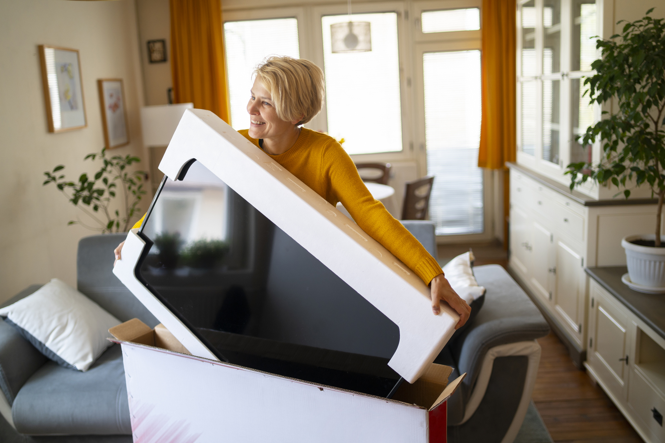 An online shopper lifts her new purchase from its box